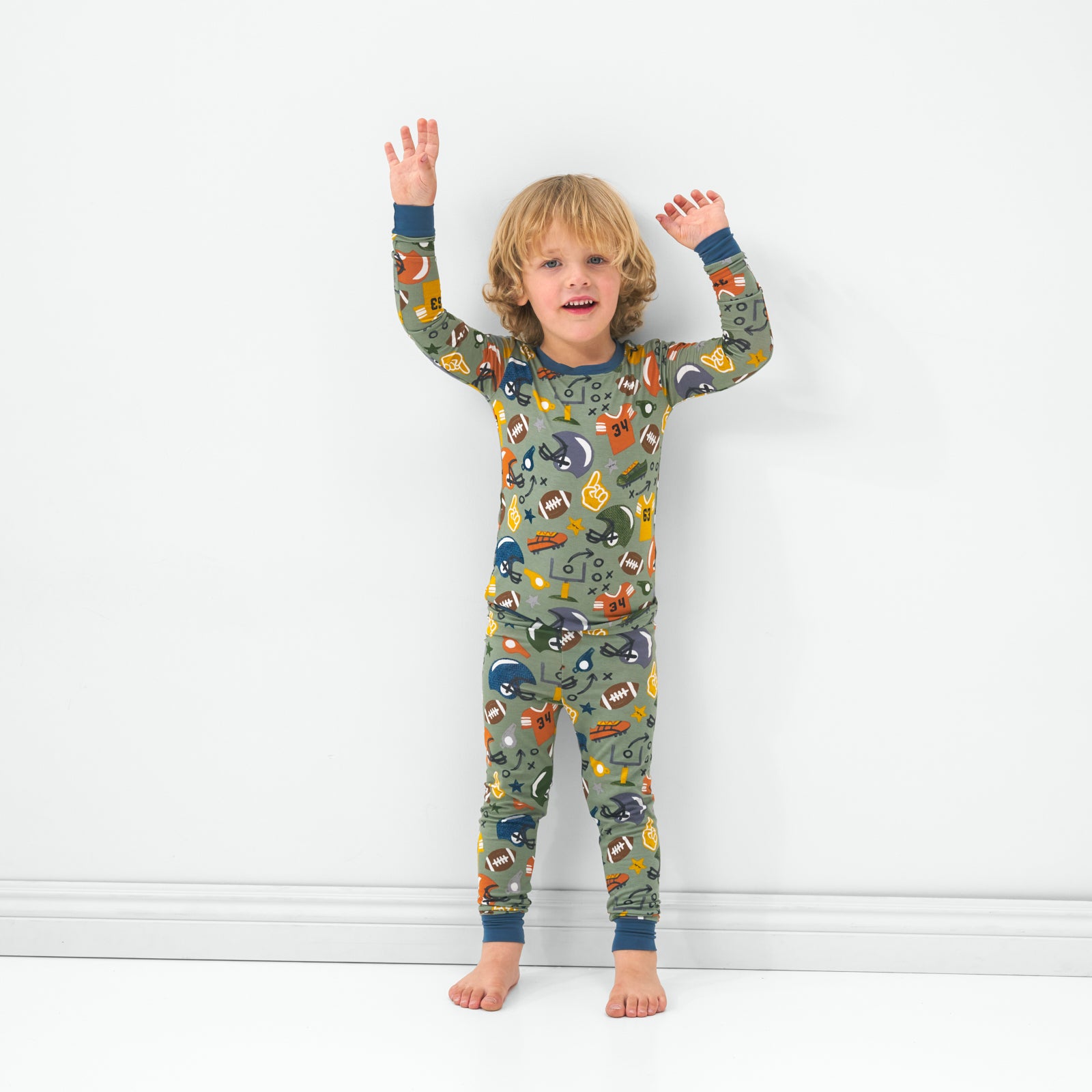 Standing child wearing the Touchdown Time two-piece bamboo pajama set