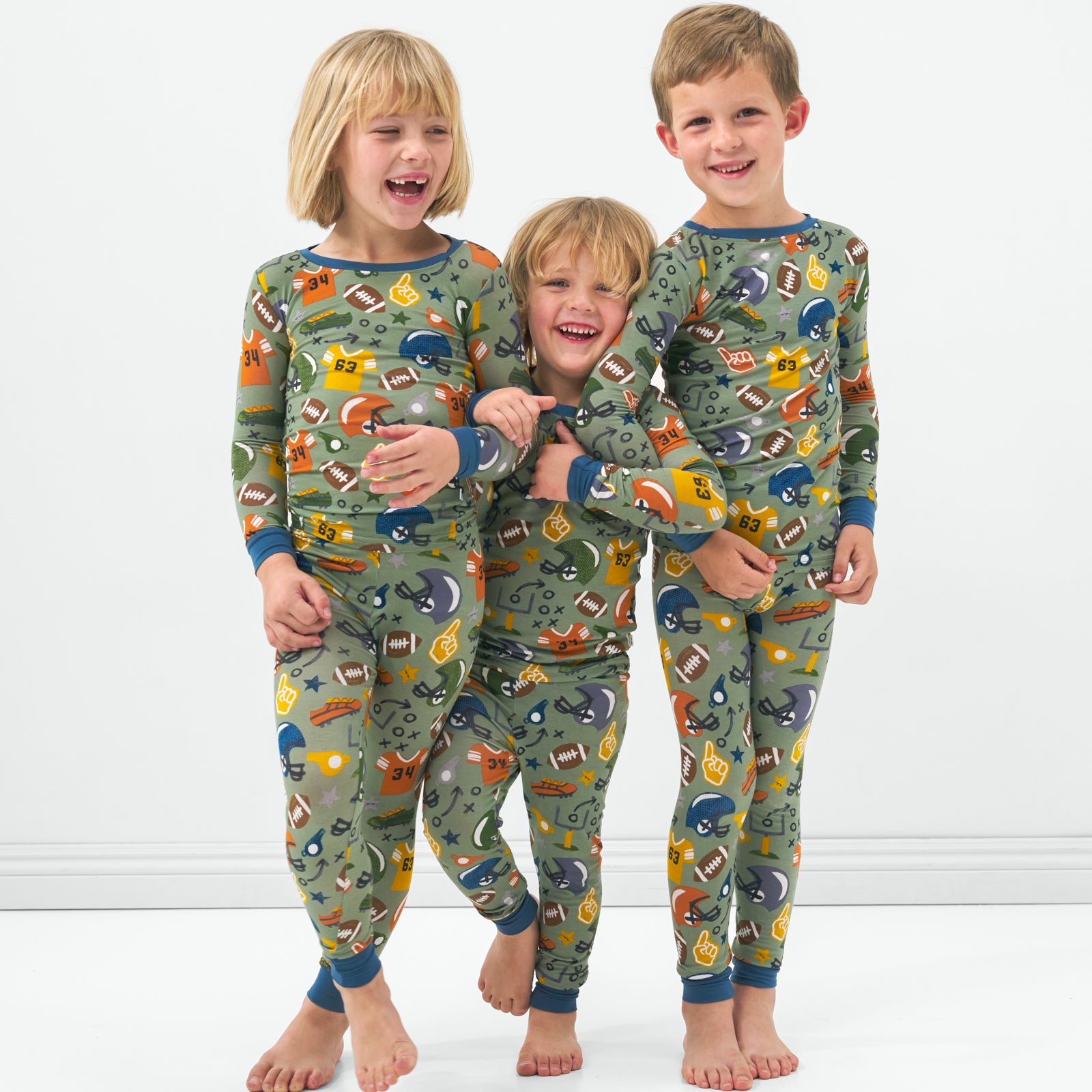 Three children in matching Touchdown Time kids bamboo pajamas
