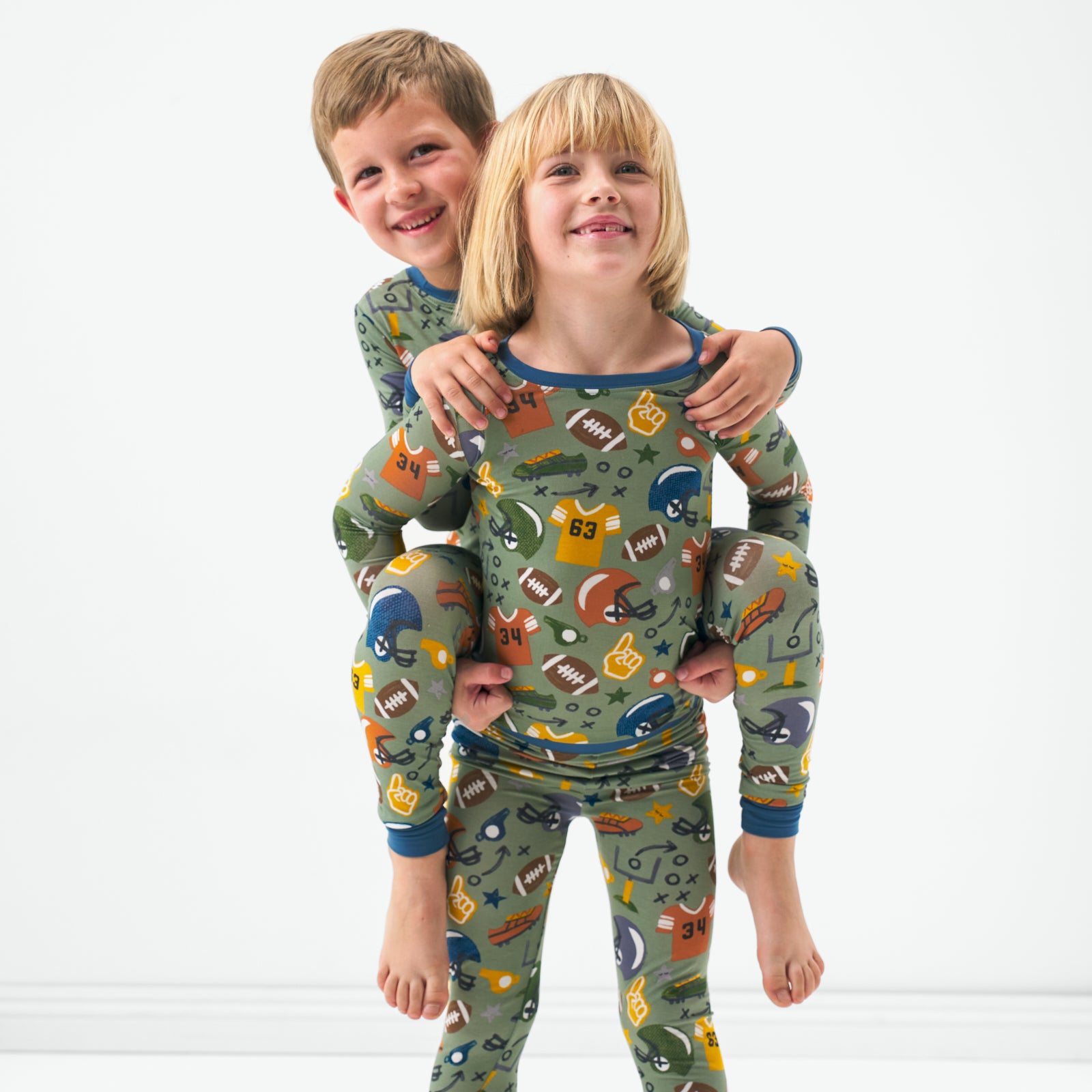 Two children wearing matching Touchdown Time childrens pajamas
