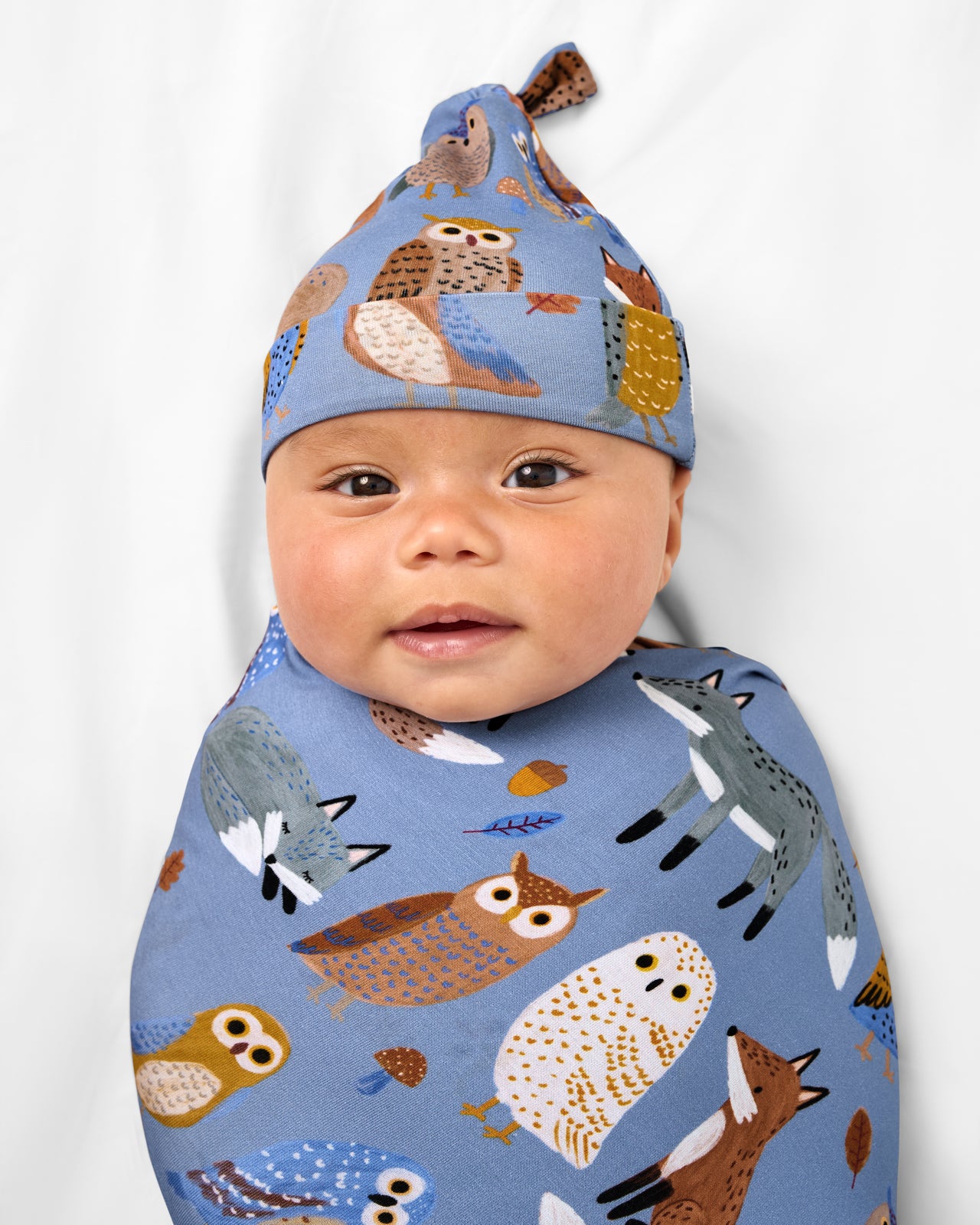 Close up of baby wearing the Twilight Pals Swaddle & Hat Set