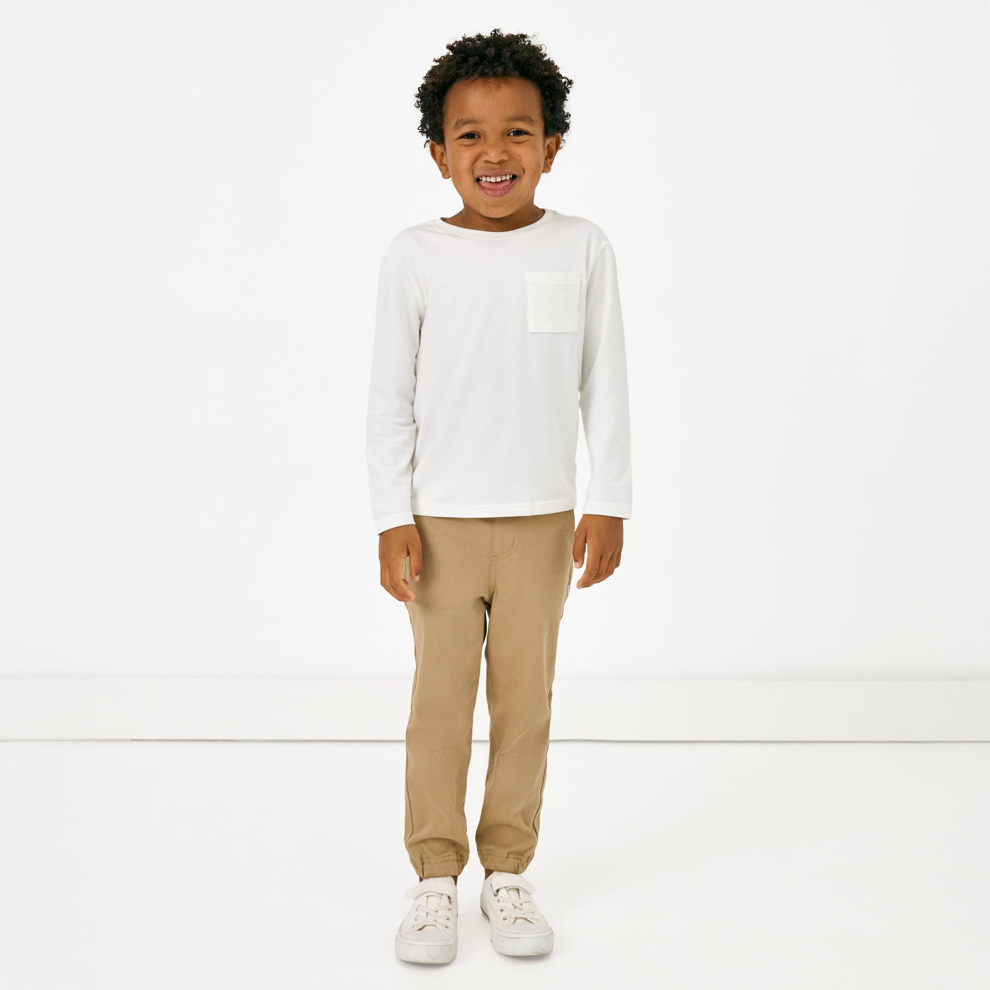 Standing child wearing the Toasted Hazelnut Denim Jogger and white long sleeve tshirt
