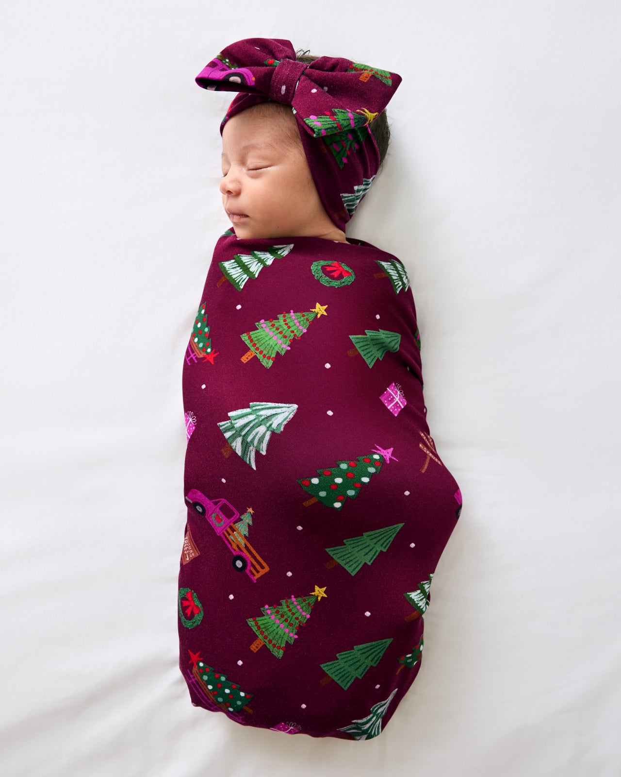 Aerial view of baby in the Cranberry Tree Traffic Swaddle & Luxe Bow Headband Set