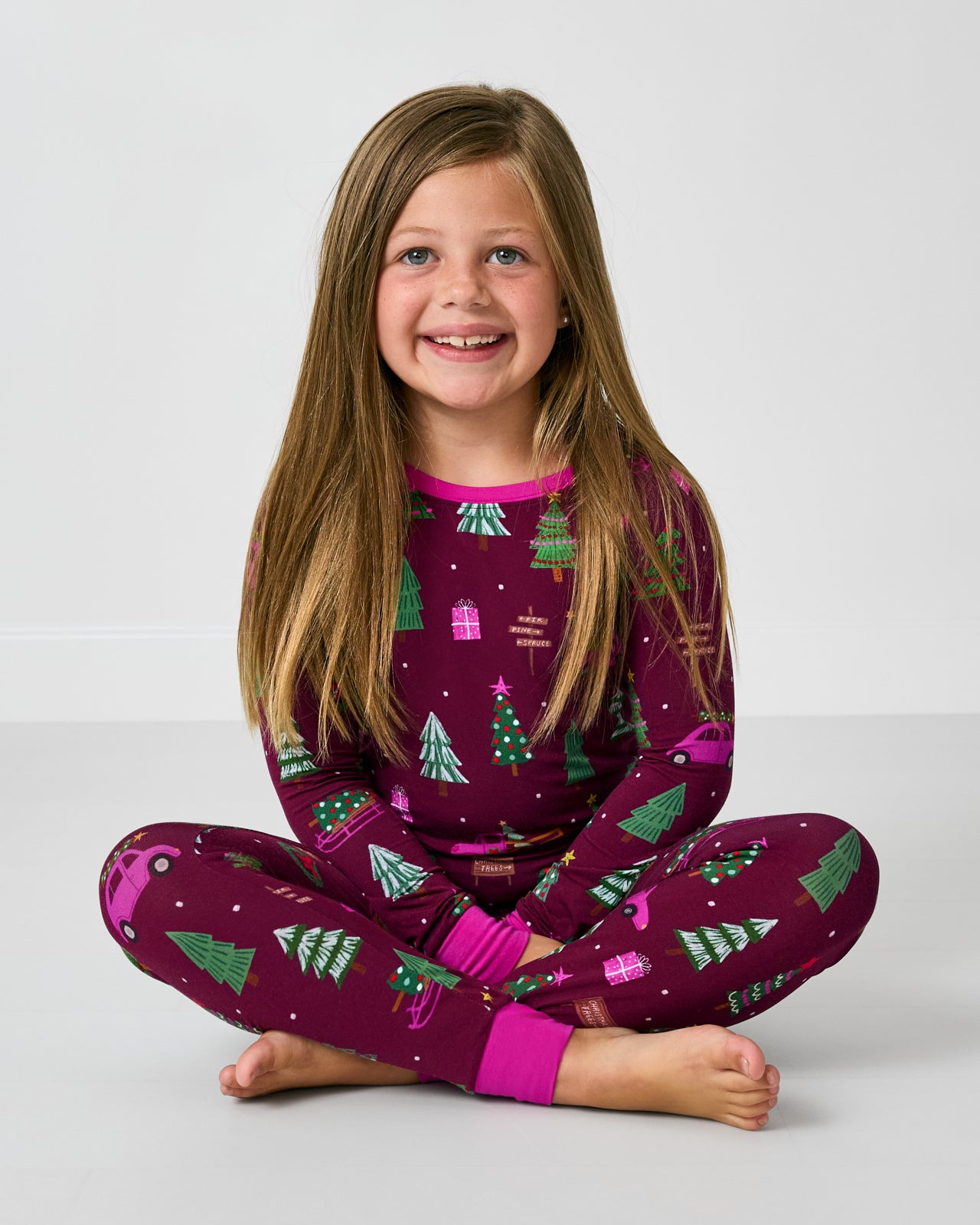 Sitting girl wearing the Cranberry Tree Traffic Two-Piece Pajama Set