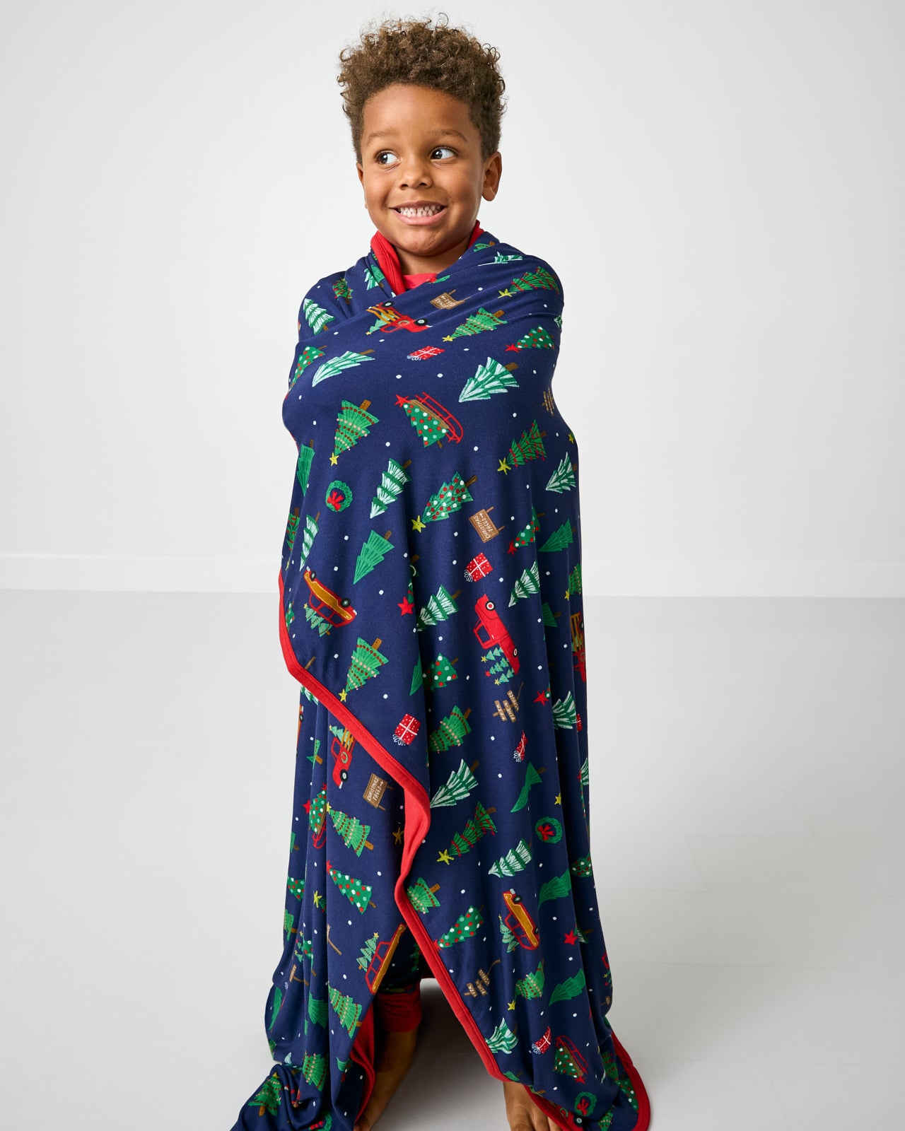 Standing boy wrapped in the Navy Tree Traffic Large Cloud Blanket®