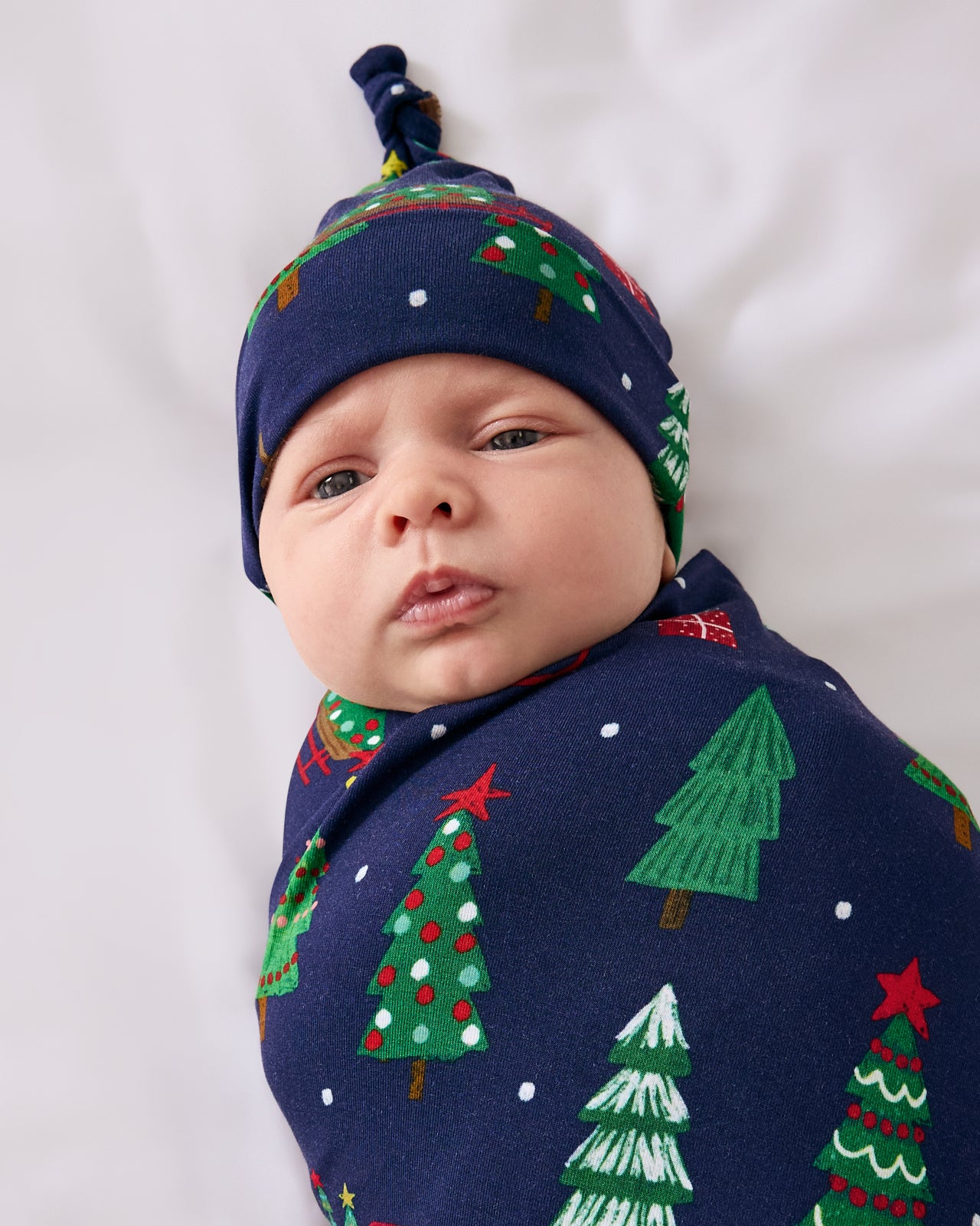 Close up of baby wearing the Navy Tree Traffic Swaddle & Hat Set