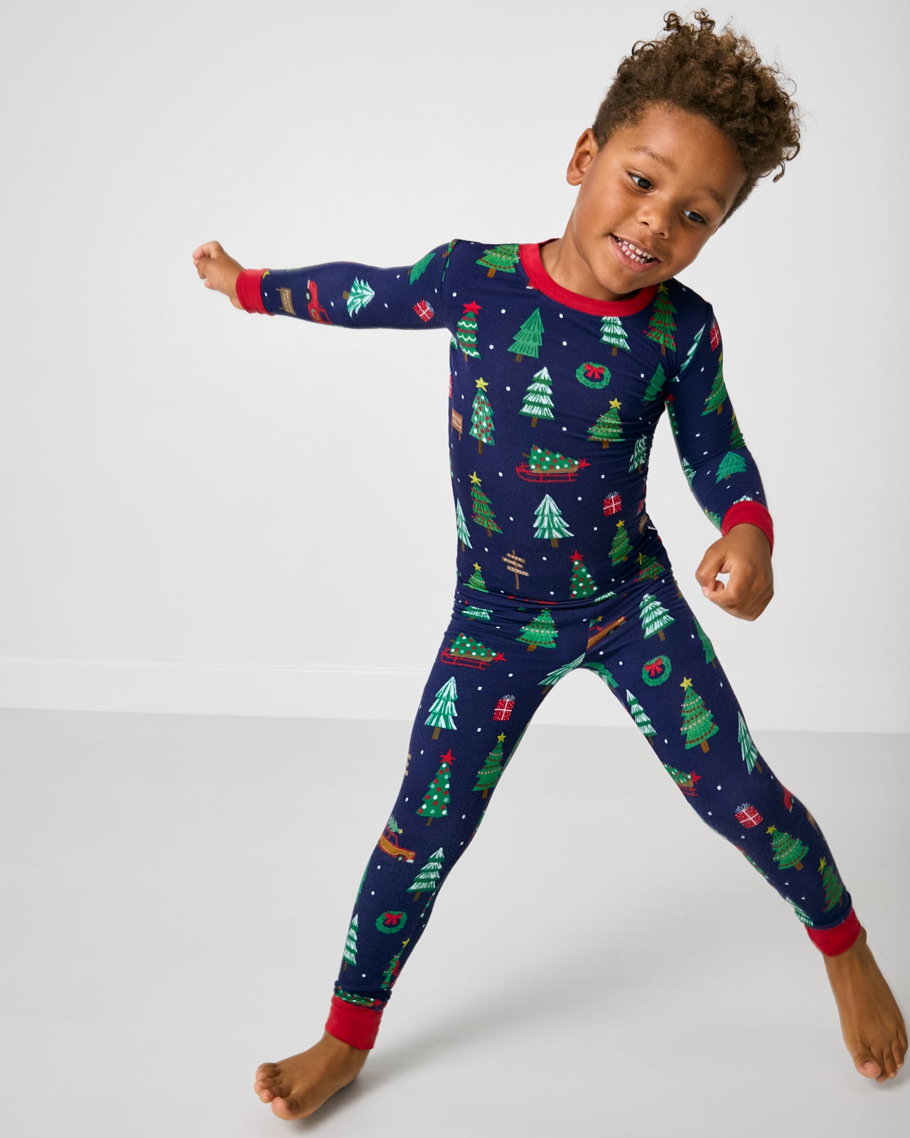 Child in motion wearing the Navy Tree Traffic Two-Piece Pajama Set