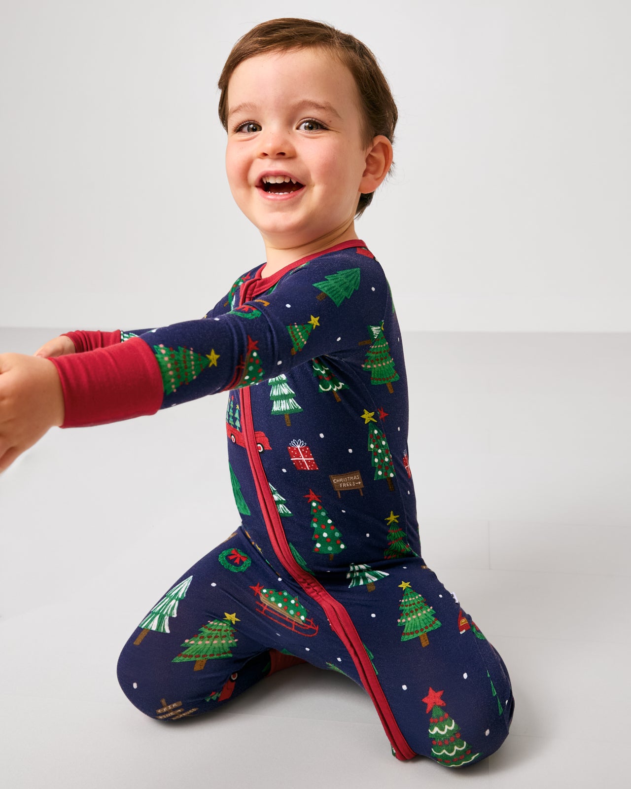 Sitting child wearing the Navy Tree Traffic Zippy