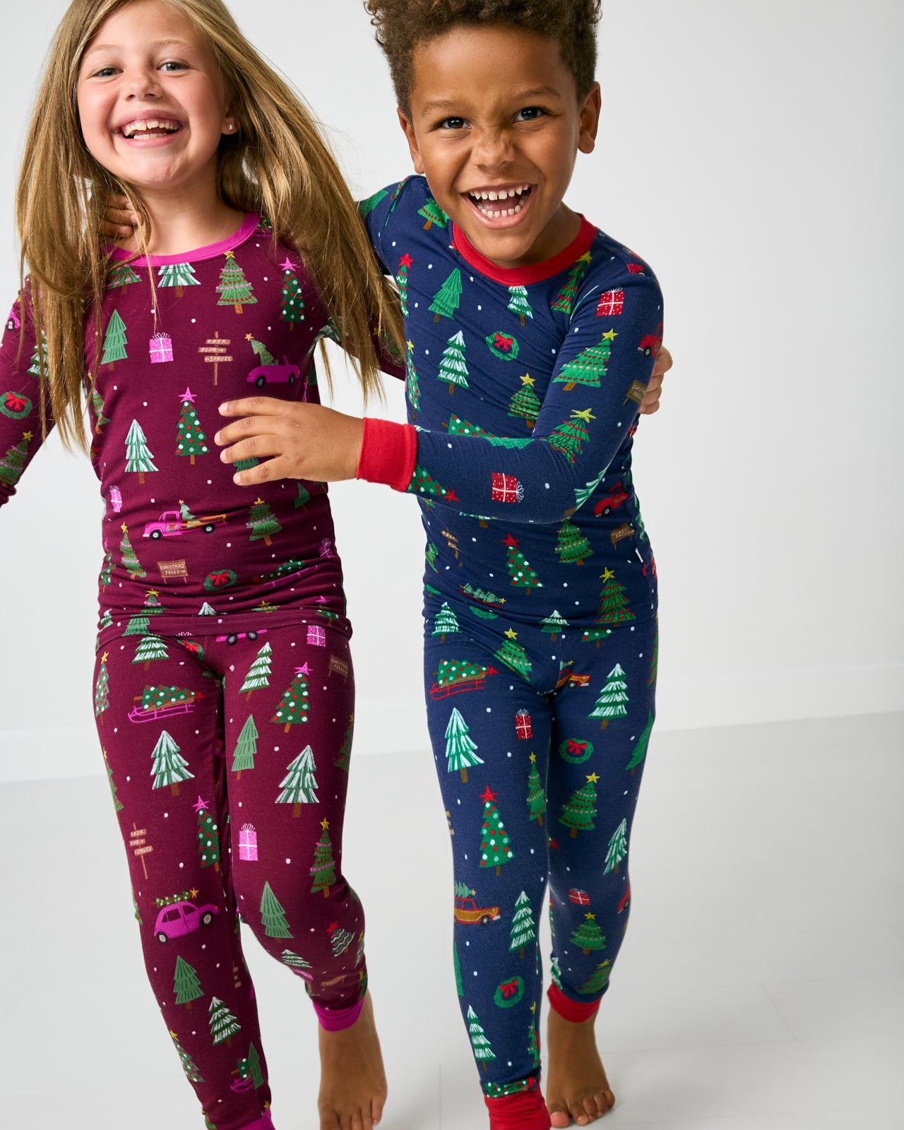 Two kids wearing matching Tree Traffic Two-Piece Pajama Sets