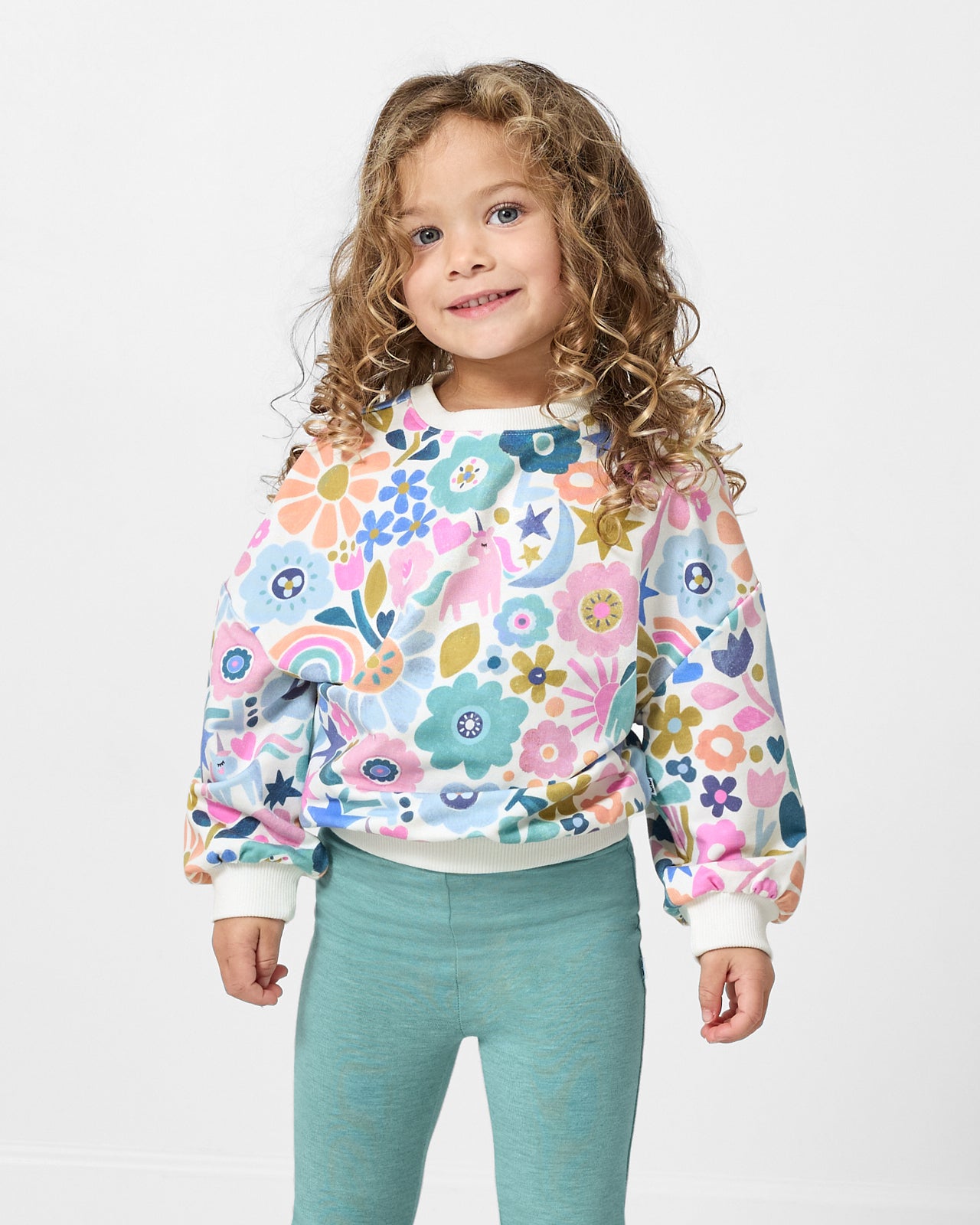 Girl wearing the Unicorn Blossoms Drop Shoulder Crewneck with blue leggings