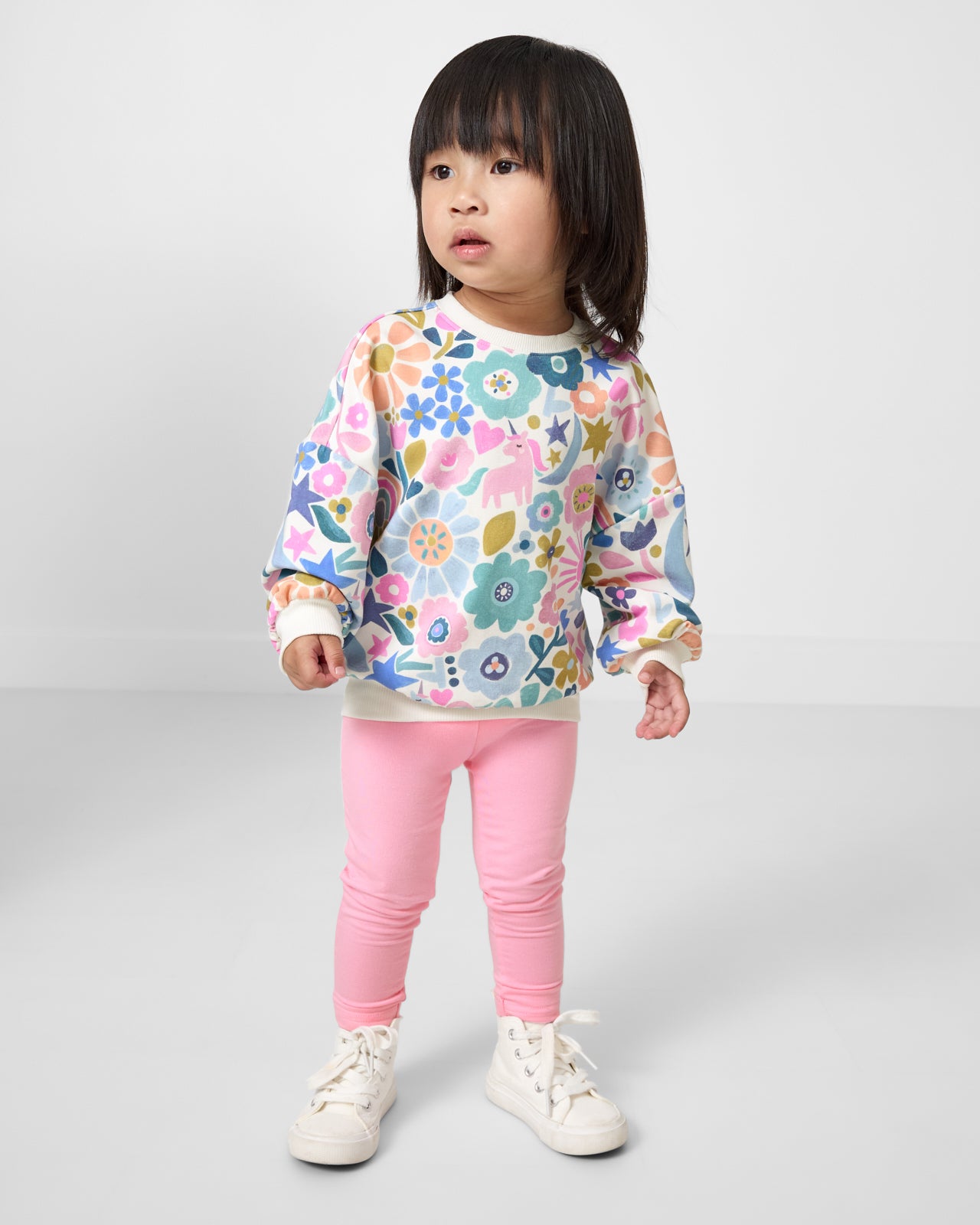 Toddler wearing the Unicorn Blossoms Drop Shoulder Crewneck with pink leggings