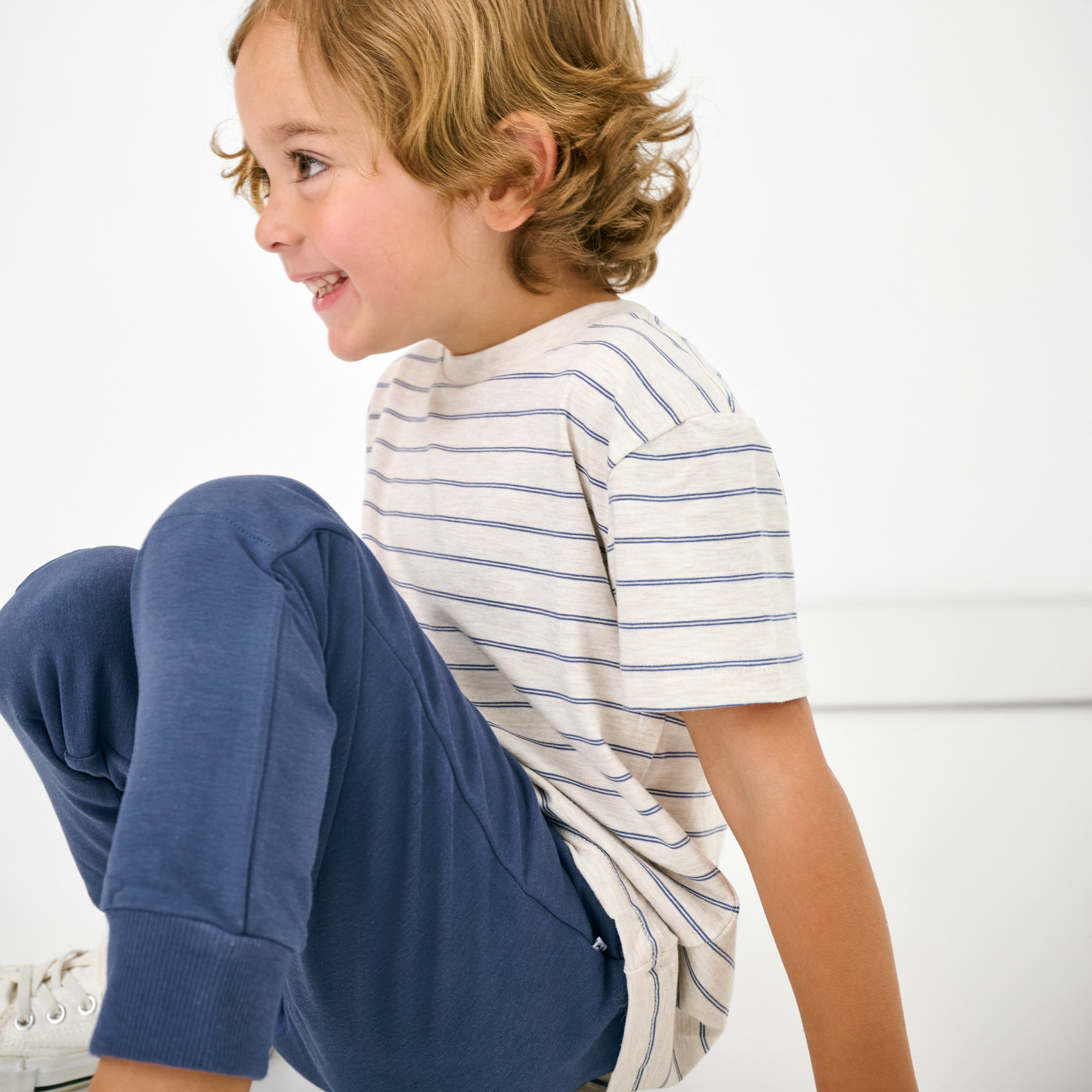 Close up of child wearing the Vintage Navy Jogger with the stone stripes tee