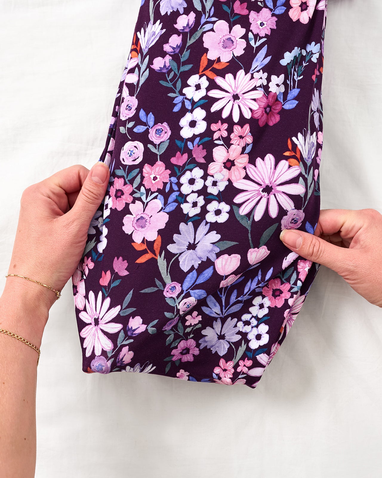 Adult adjusting the envelope sweep on the Violet Meadow Infant Gown