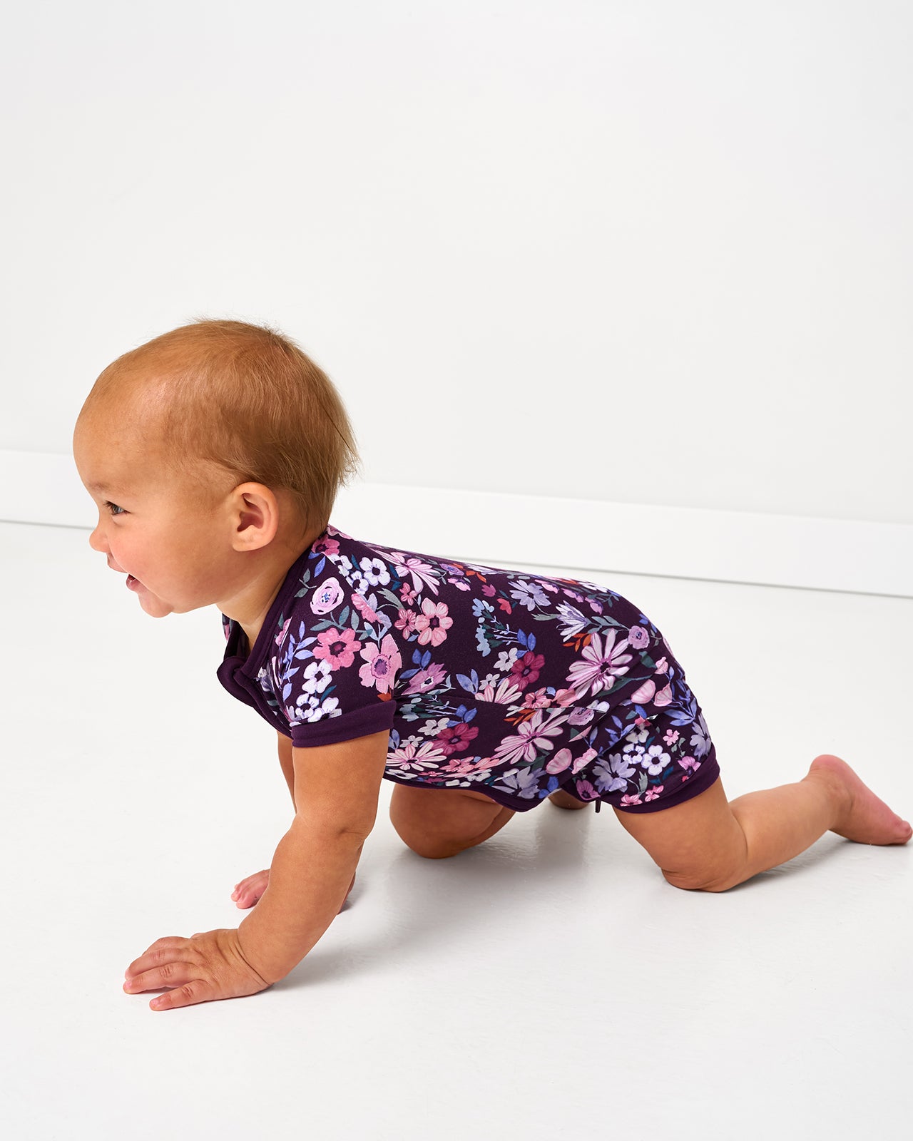 Crawling baby wearing the Violet Meadow Shorty Zippy