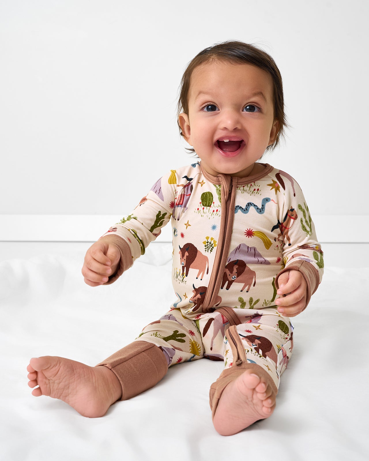 Sitting baby wearing the Wild Frontier Zippy