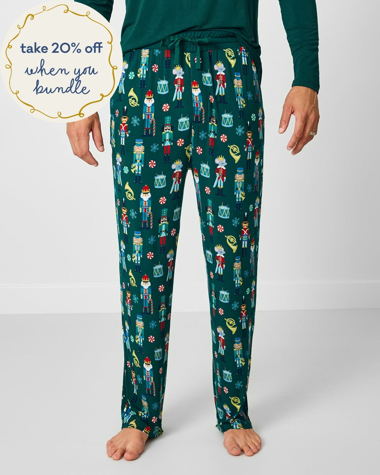 Man wearing the Nutcracker March Men's Pajama Pants with a green top