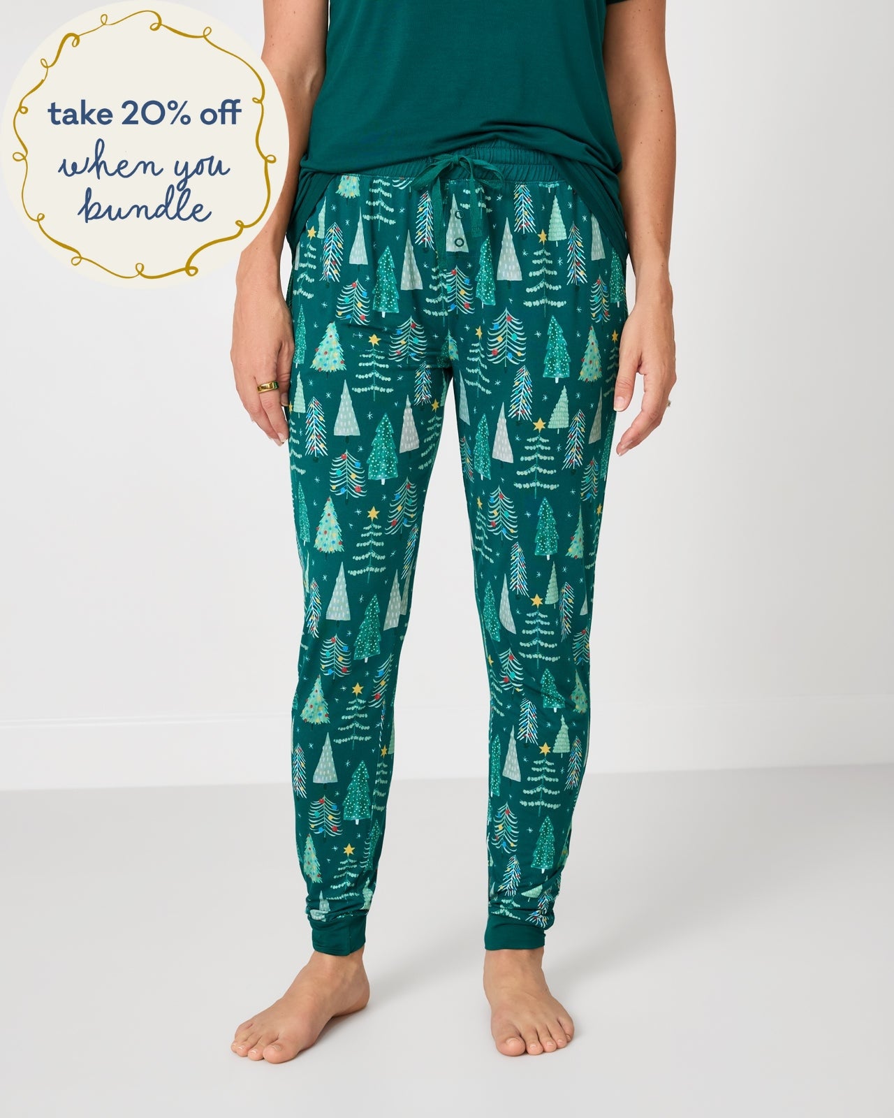 Woman wearing the Twinkling Trees Women's Pajama Pants with a green pajama top