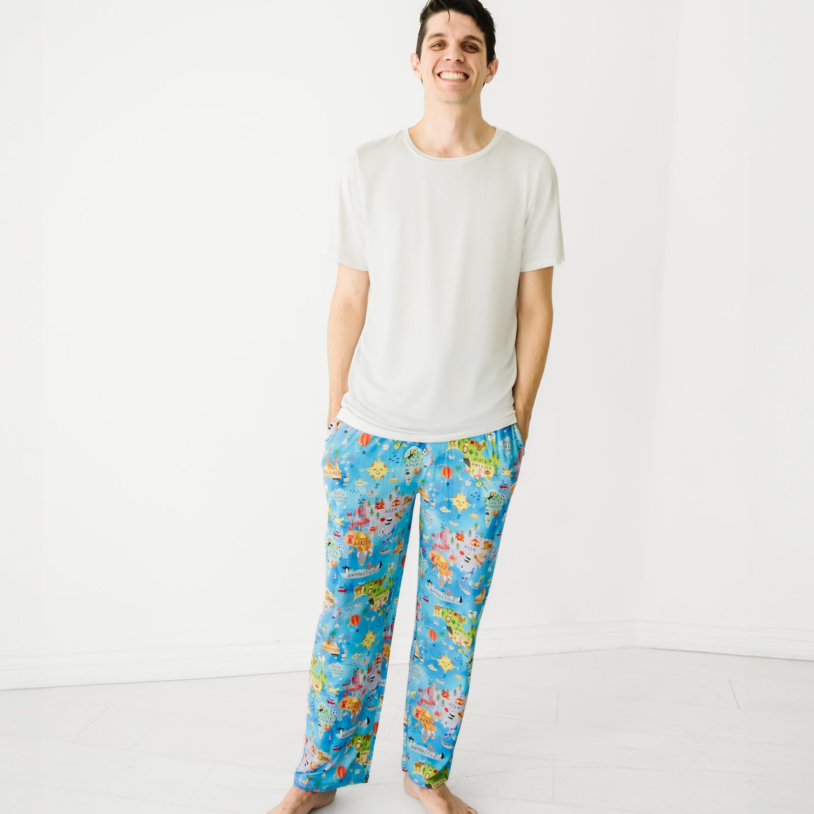 Man posing wearing Around the World bamboo men's pajama pants and a matching white top