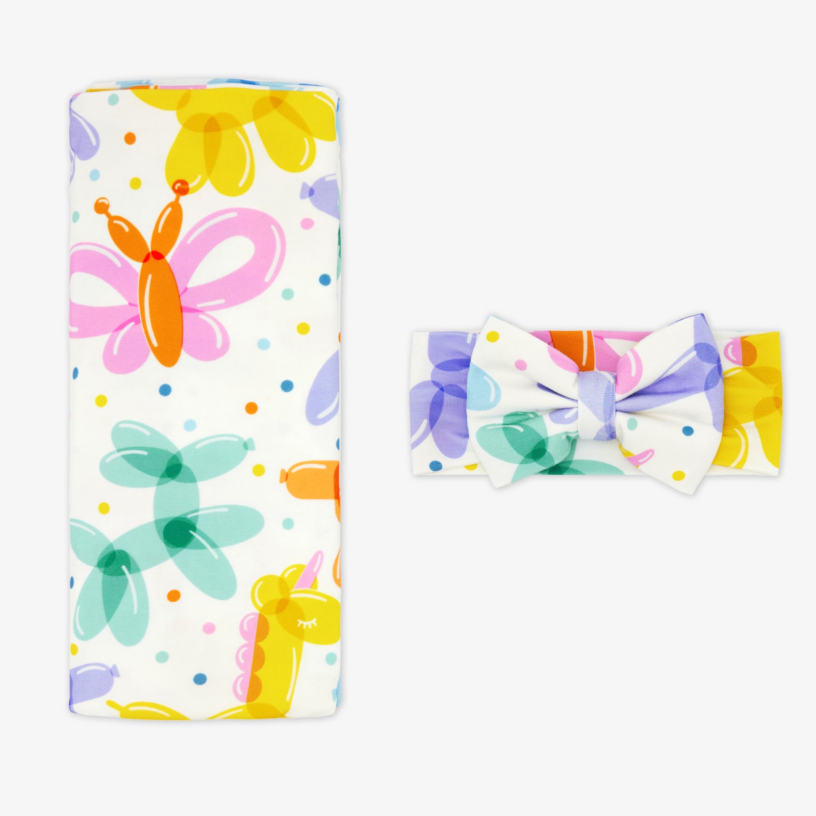 Flat lay of the Balloon Bash Swaddle & Luxe Bow Headband Set