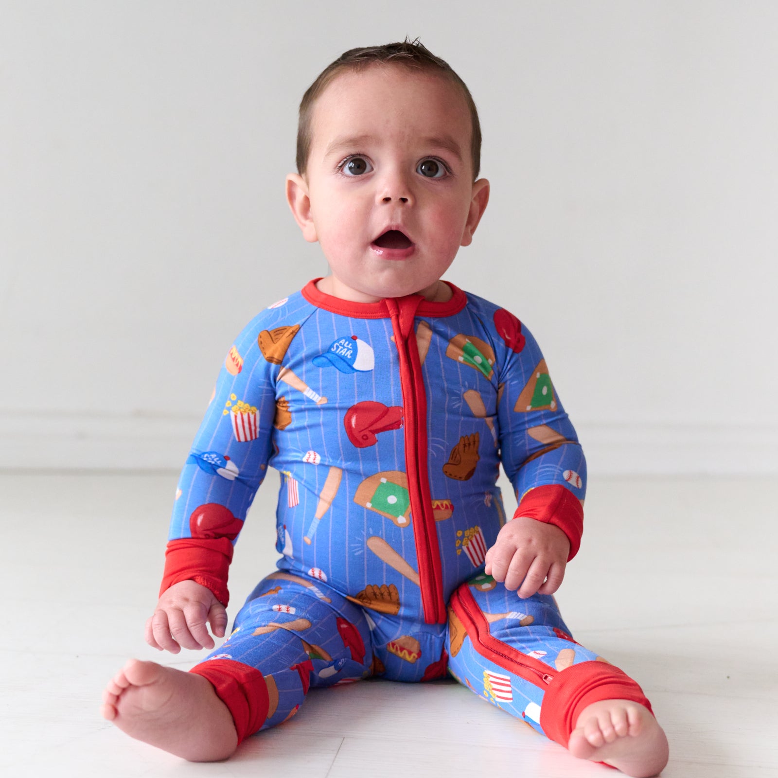 Child sitting wearing a Blue All Stars bamboo zippy