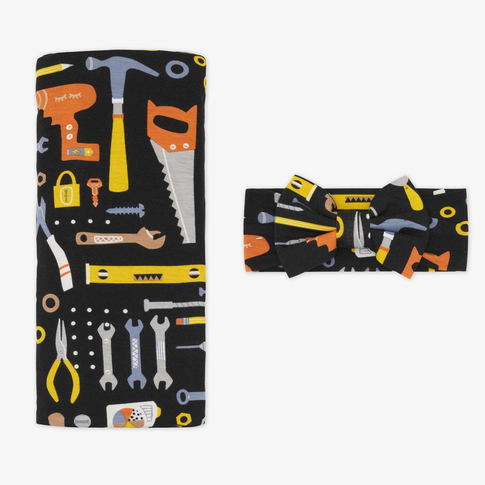 Flat lay of the Little Builders Swaddle & Luxe Bow Headband Set