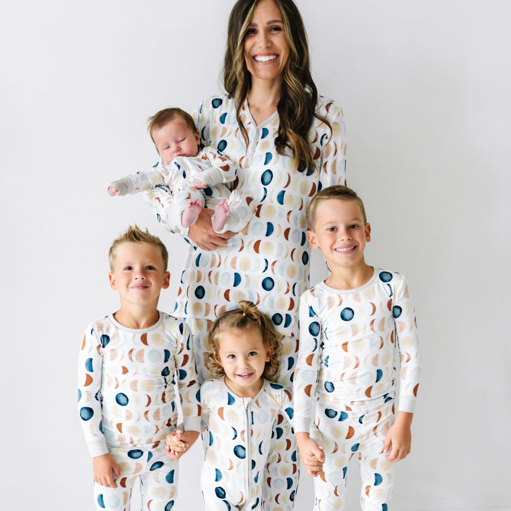 Mother and her four children wearing matching Luna Neutral pajamas. Mom is wearing women's Luna Neutral pajama top and matching pants. Her children are wearing Luna Neutral pajamas in two piece and zippy styles