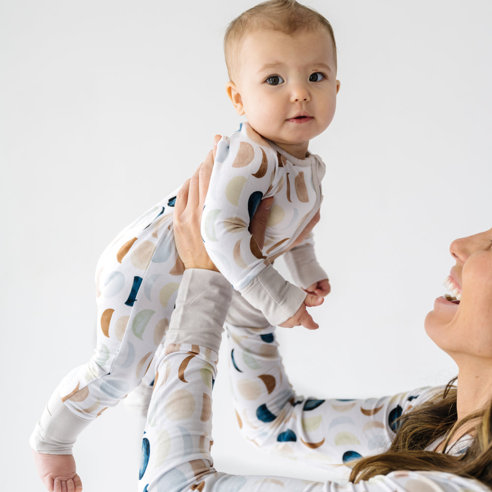 Mother wearing a Luna Neutral women's pj top holding up her child wearing a matching Luna Neutral zippy