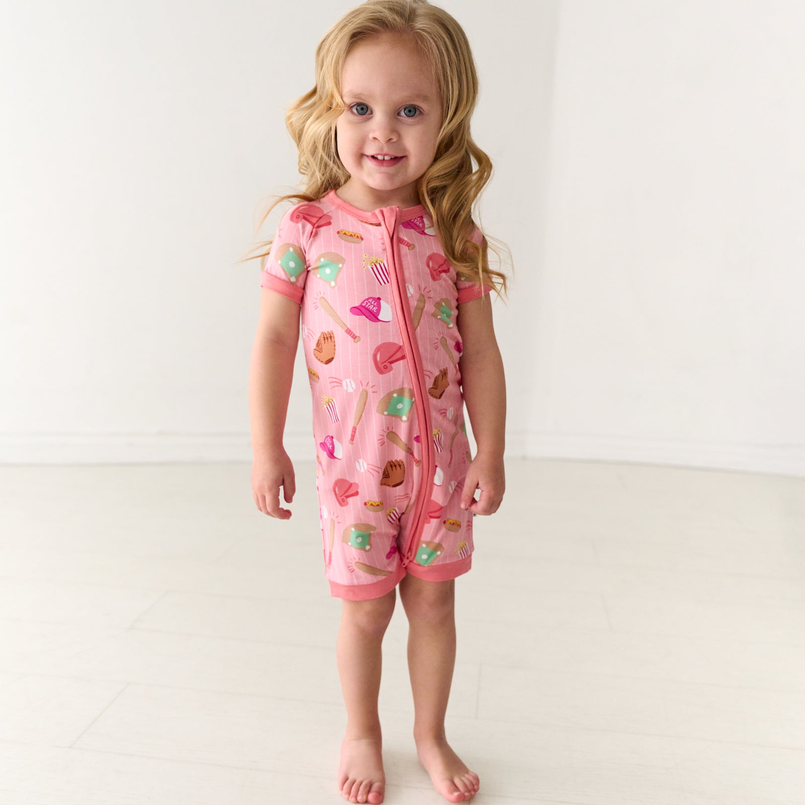 Smiling child wearing a Pink All Stars bamboo shorty zippy