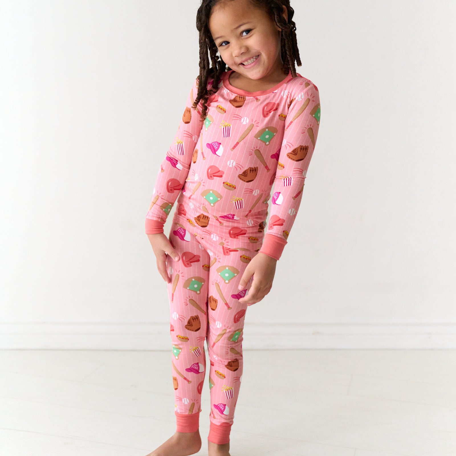 Child wearing a Pink All Stars two-piece long sleeve and pants kids bamboo pajama set