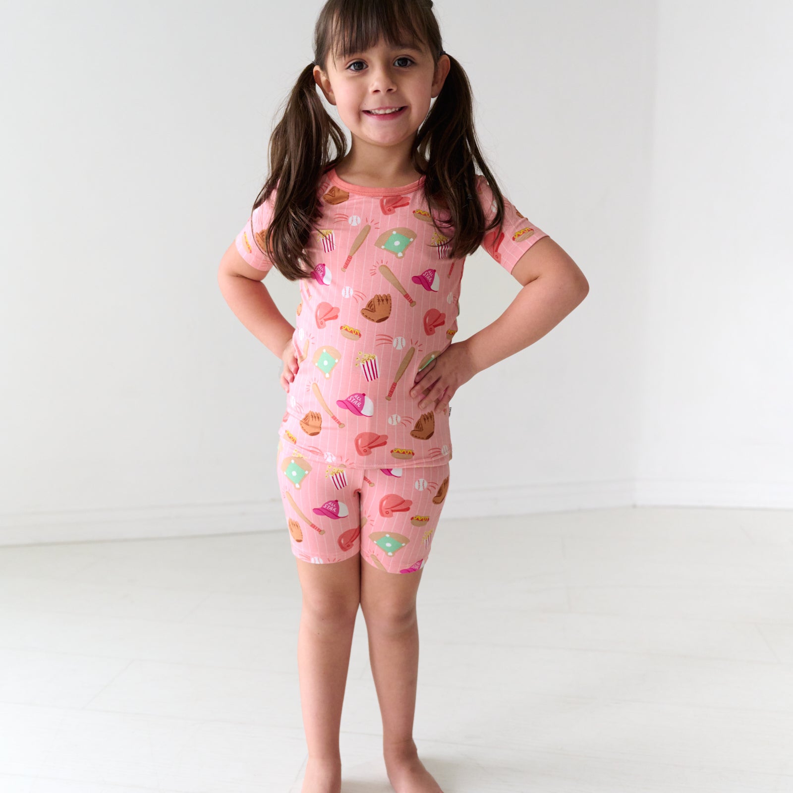 Child wearing a Pink All Stars two piece short sleeve and shorts bamboo pajama set