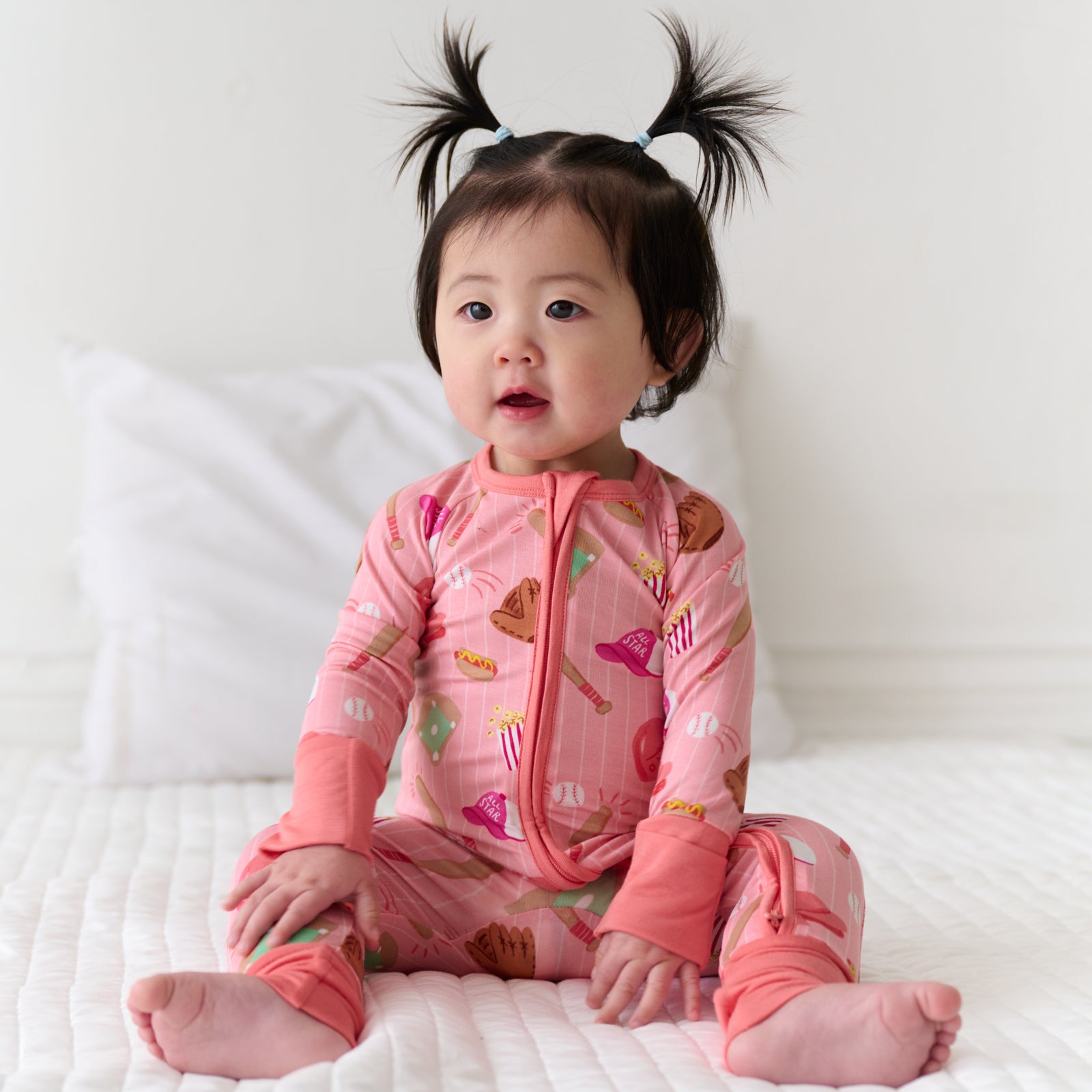 Child sitting wearing a Pink All Stars bamboo zippy