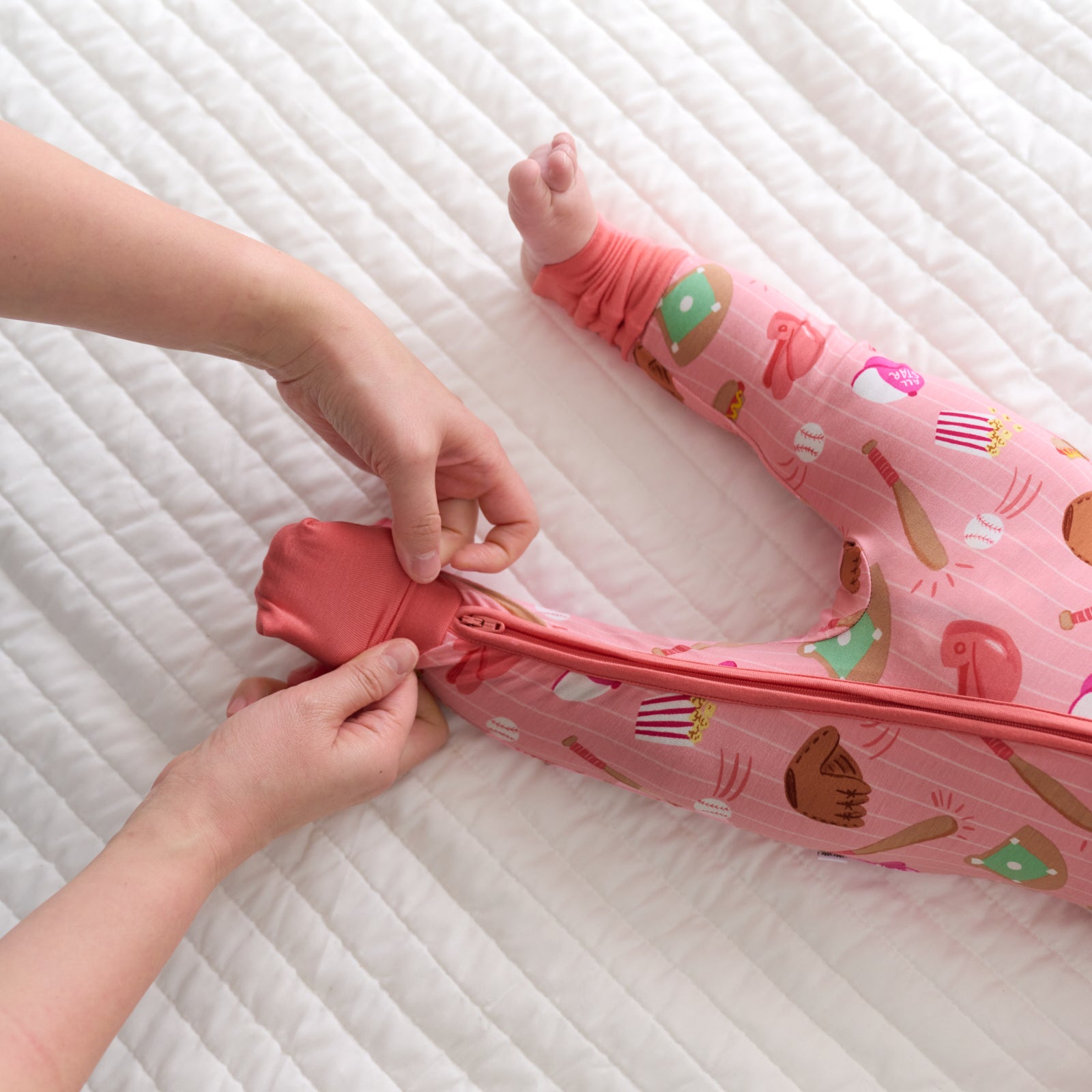 Close up of a parent folding over the convertible foot cuff of a Pink All Stars bamboo zippy