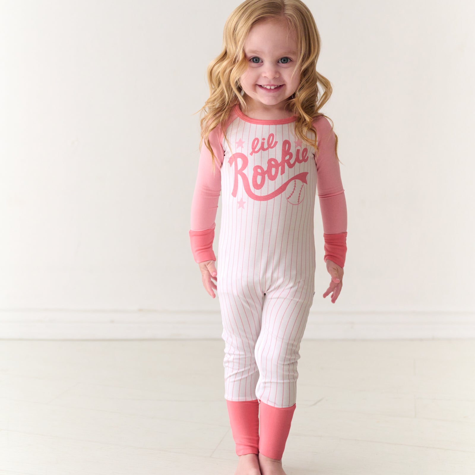 Smiling child wearing a Pink Lil Rookie bamboo crescent zippy