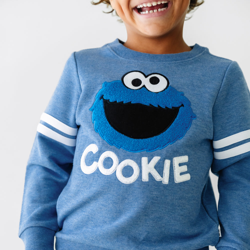 Alternate close up image of a child wearing a Sesame Street Cookie Monster crewneck sweatshirt and jogger set