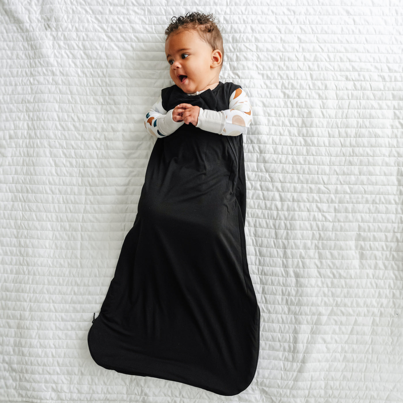 Aerial view of baby wearing the Black Sleepy Bag