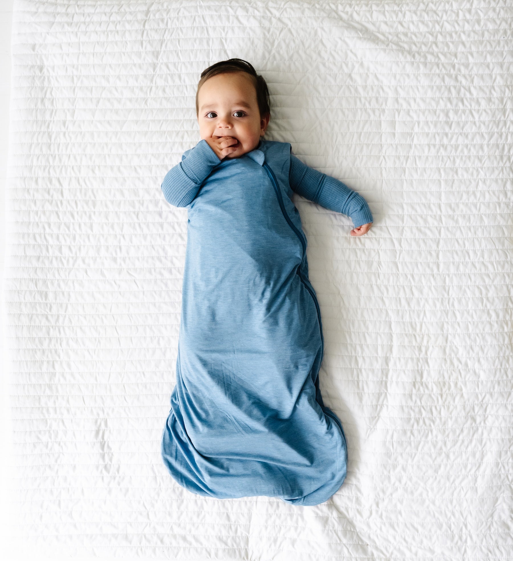 Aerial view of baby wearing the Heather Blue Sleepy Bag