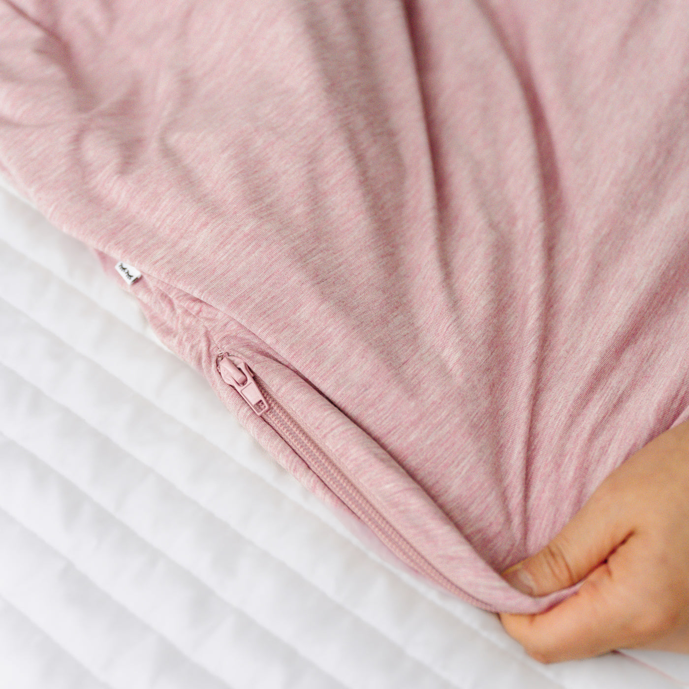 Close up detail image of the zipper on a Heather Mauve sleepy bag