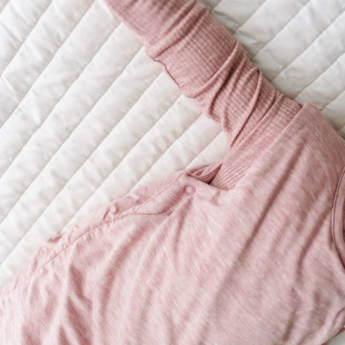 Close up detail image of the adjustable arm snaps on a Heather Mauve sleepy bag