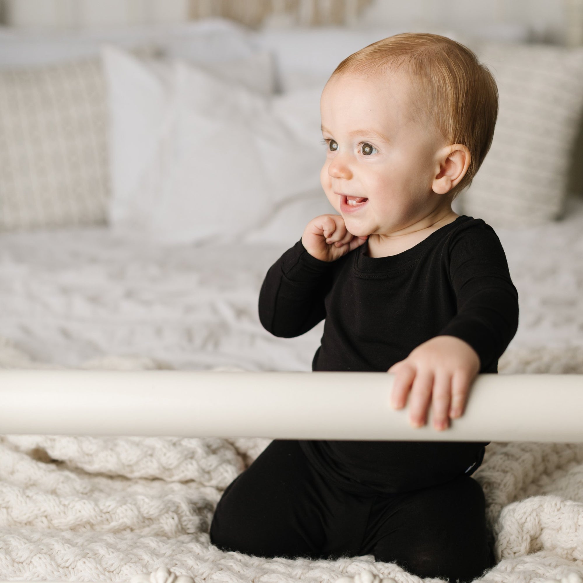 Baby girl wearing solid black two-piece pajama set.