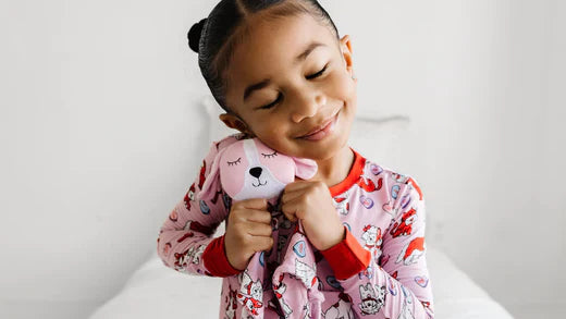 girl wearing furever valentines pjs and holding a matching sleepyhead lovey