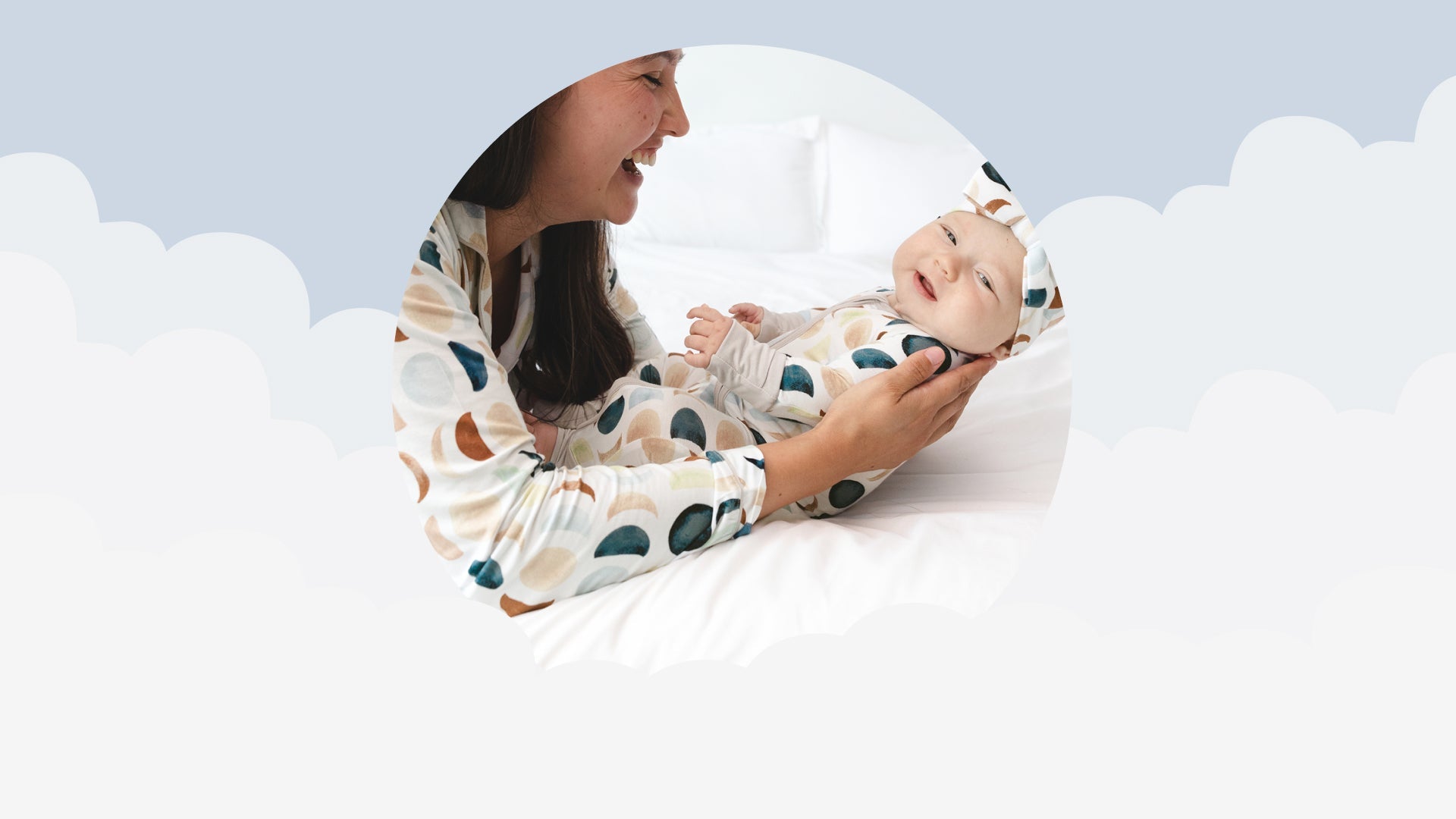 Mother holding her newborn, both wearing matching Luna Neutral bamboo pajamas