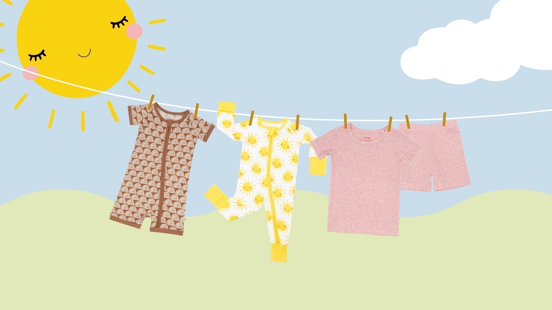 flat lays of a rust rainbows shorty zippy, sunshine zippy, and heather mauve ribbed two-piece pajamas set hanging on a clothesline with a sun and clouds in the sky