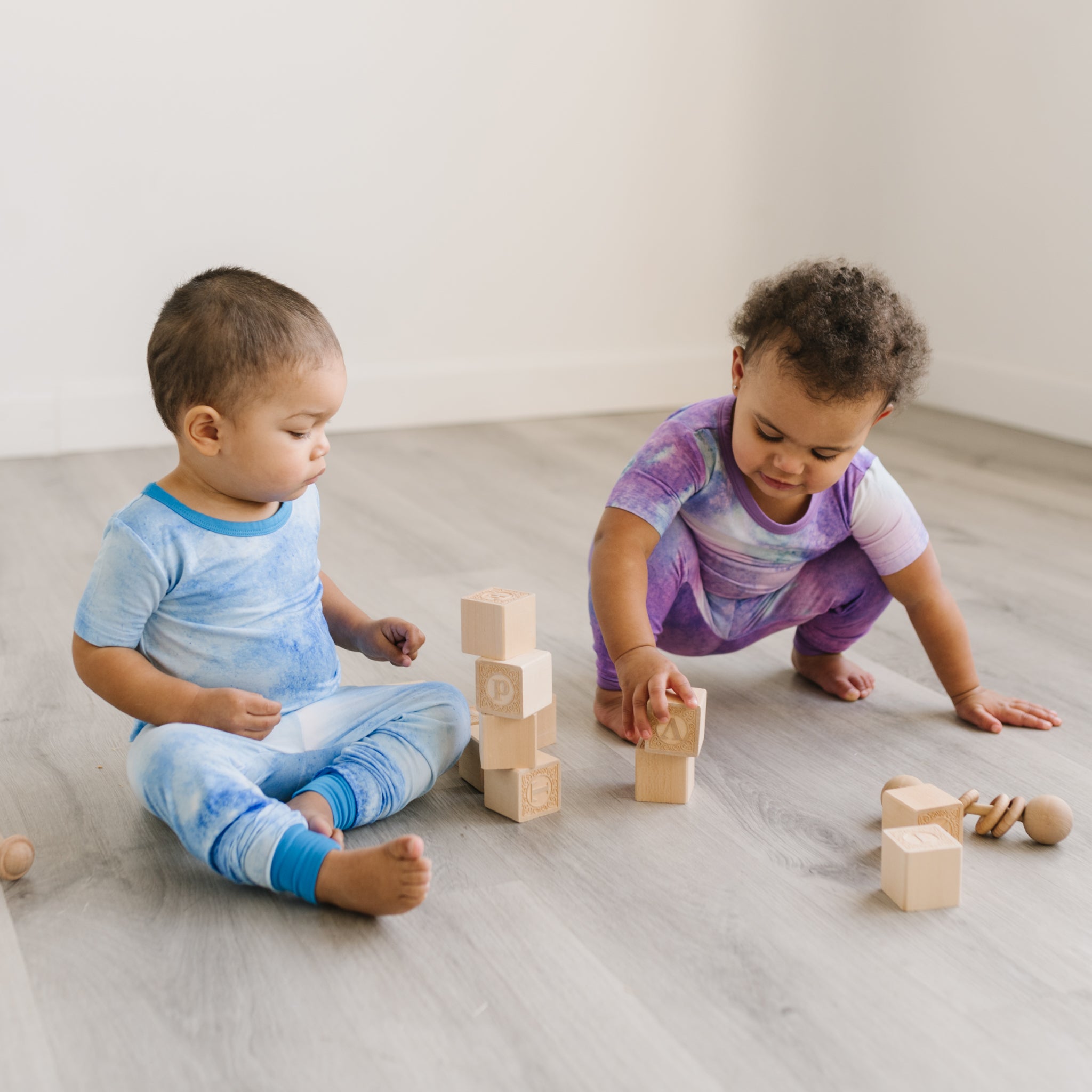 two kids in pajamas playing with blocks