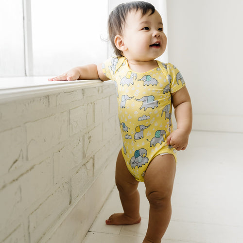 infant wearing a bodysuit with elephants on it