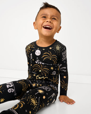 Boy wearing Cozy Countdown New Years themed pajamas