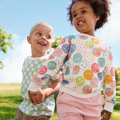 children holding hands wearing Play by Little Sleepies outfits in Watercolor Checks and Positive Vibes