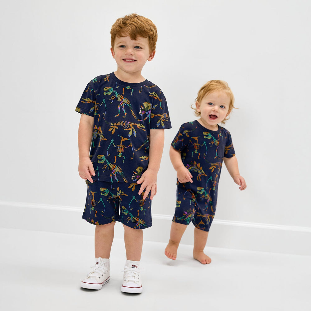 Two children wearing matching dinosaur print back to school styles