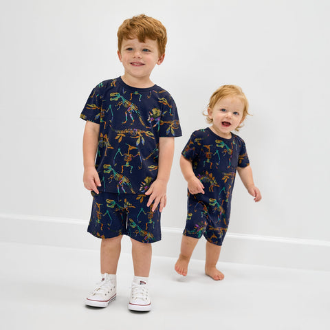 Two children wearing matching dinosaur print back to school styles