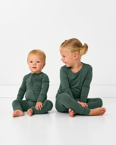 Two children wearing matching Grove Green pajamas