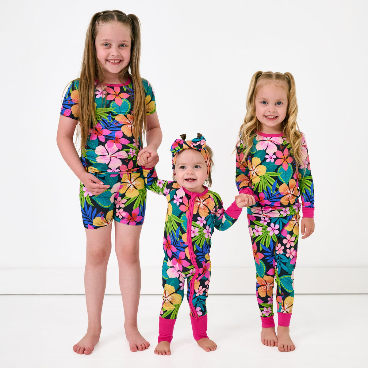 Three children wearing matching Jungle Blooms pjs