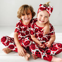 two children wearing matching Love Bug printed pajama sets